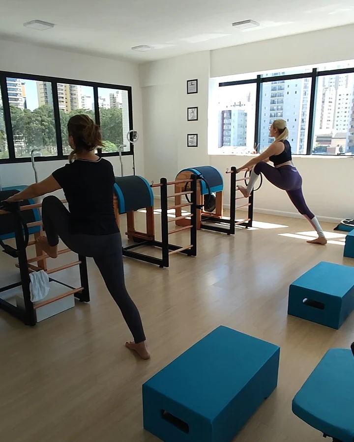 Duas alunas em exercício apoiadas nos barrels