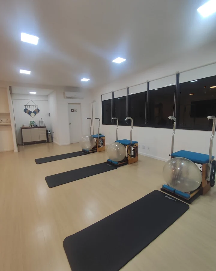 Sala preparada para aula no solo, com colchonetes estendidos