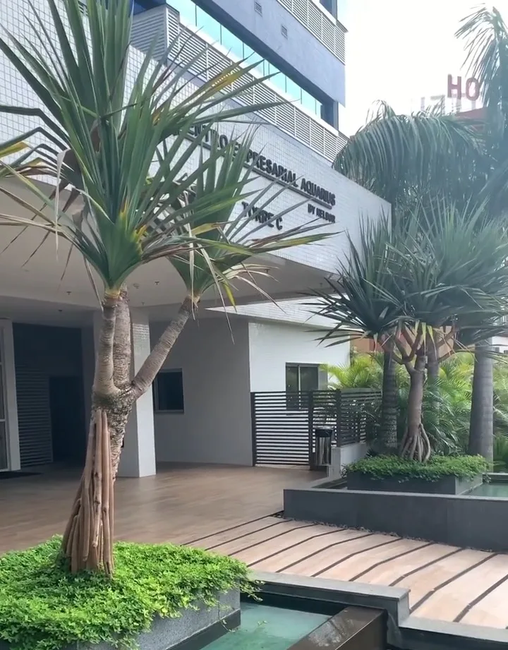 Entrada do Centro Empresarial Aquarius, com jardim, palmeiras e espelho d'água
