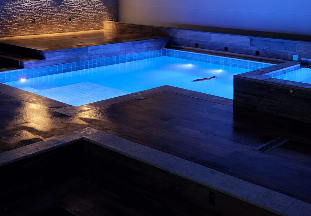 Piscina iluminada à noite construída pela Nova Opção